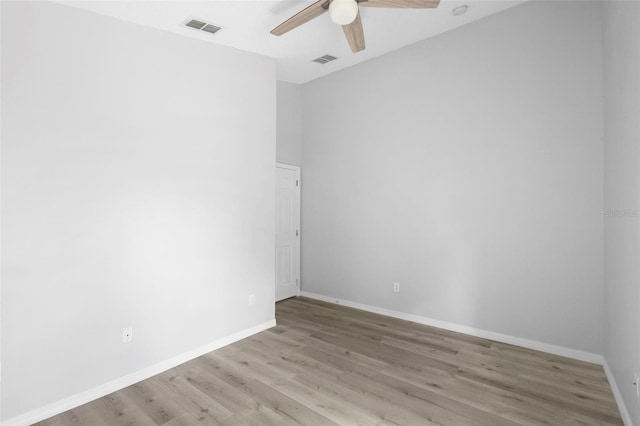 empty room featuring a ceiling fan, light wood finished floors, and baseboards