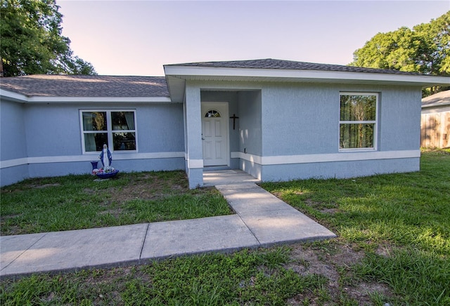 view of front facade featuring a front lawn and roof with shingles
