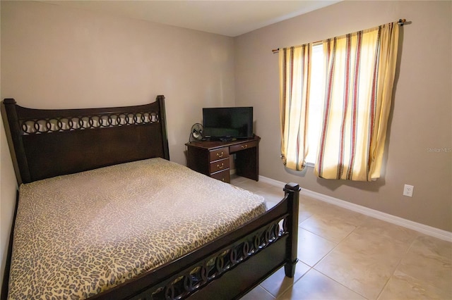 bedroom featuring light tile patterned floors and baseboards
