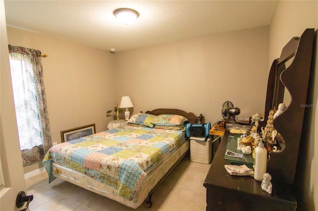 bedroom with light tile patterned floors and multiple windows