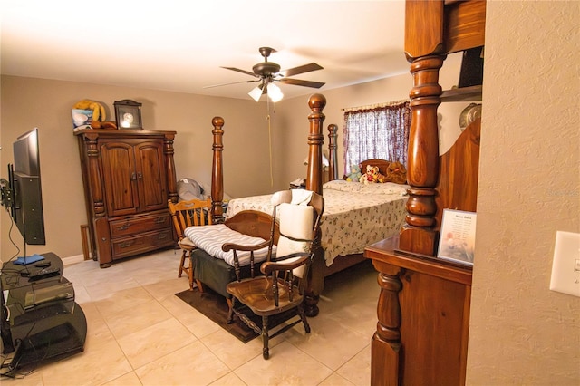 bedroom featuring light tile patterned floors, a ceiling fan, and a textured wall
