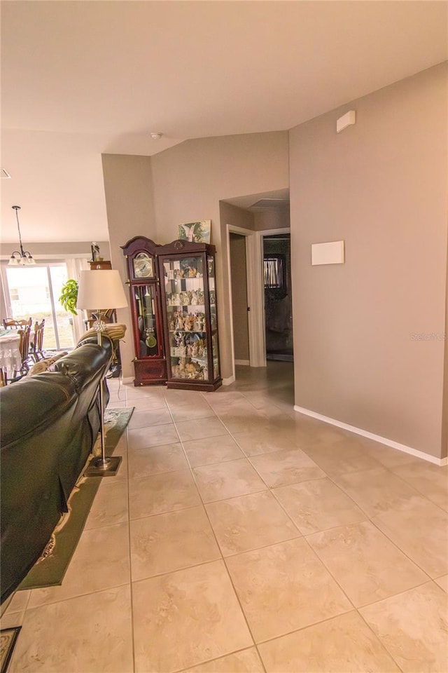 corridor featuring light tile patterned floors and baseboards