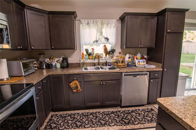 kitchen featuring appliances with stainless steel finishes, a sink, and dark brown cabinets
