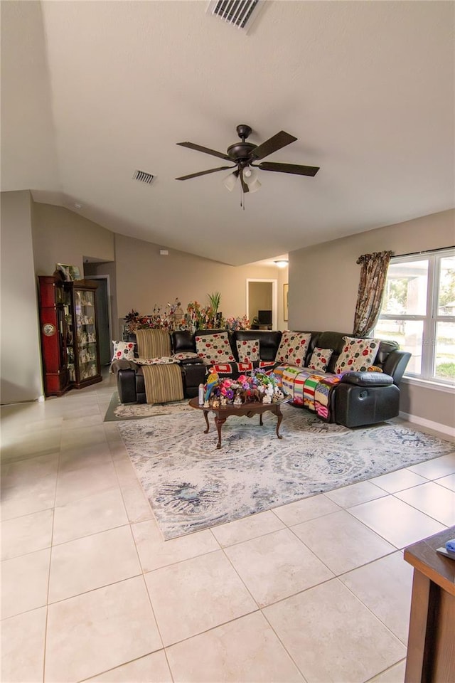 living area with ceiling fan, light tile patterned flooring, and vaulted ceiling