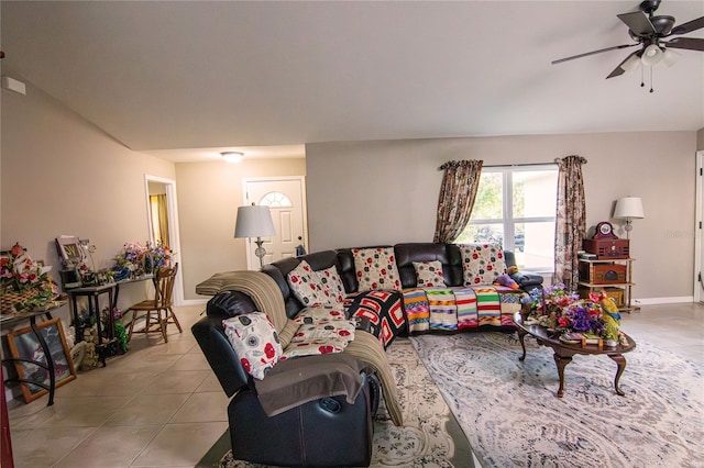 living area featuring tile patterned floors, a ceiling fan, and baseboards