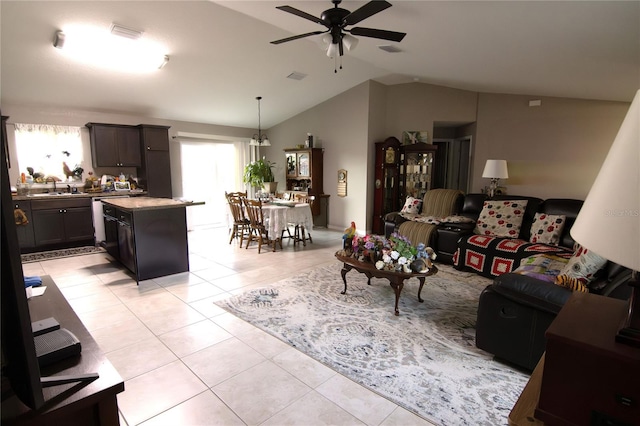 living room featuring a ceiling fan, vaulted ceiling, and light tile patterned floors