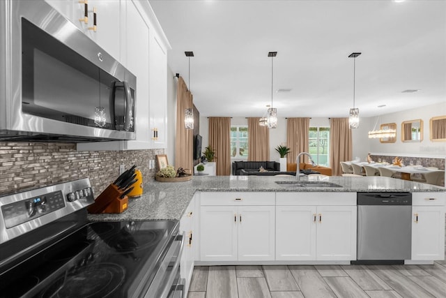 9020 Stinger Dr, Davenport, FL 33896 - kitchen with stainless steel appliances, a sink, light stone counters, and backsplash