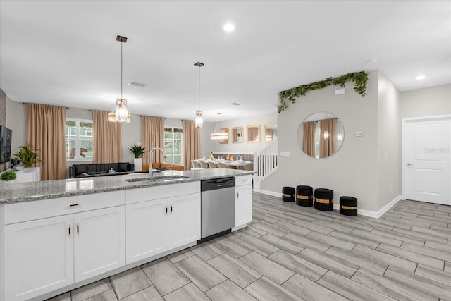 9020 Stinger Dr, Davenport, FL 33896 - kitchen with a sink, stainless steel dishwasher, light stone counters, baseboards, and white cabinets