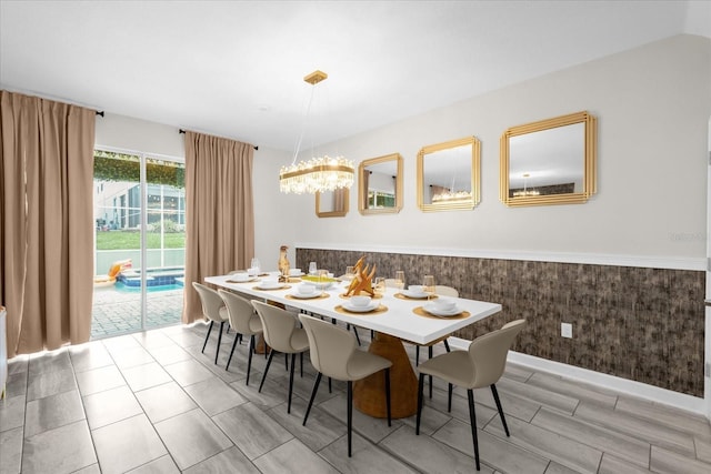 9020 Stinger Dr, Davenport, FL 33896 - dining area featuring a chandelier, a wainscoted wall, baseboards, and light wood-style floors