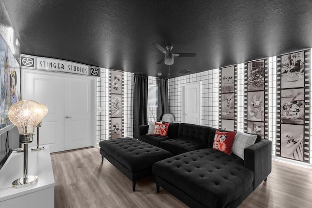 9020 Stinger Dr, Davenport, FL 33896 - living area with wood finished floors, ceiling fan, and a textured ceiling