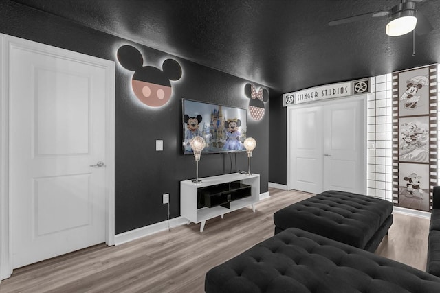 9020 Stinger Dr, Davenport, FL 33896 - living area featuring a textured wall, wood finished floors, baseboards, and ceiling fan