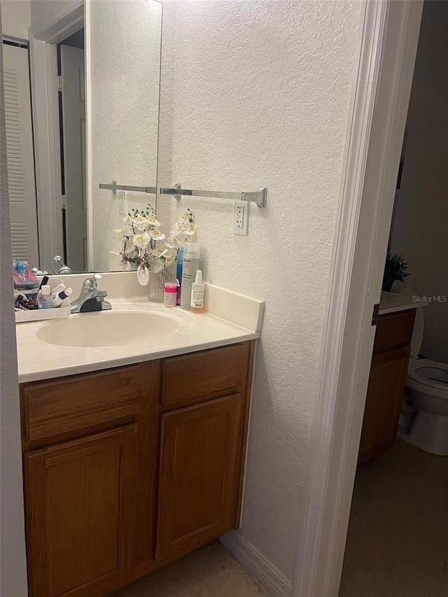 2203 San Vittorino Cir Unit 103, Kissimmee, FL 34741 - bathroom with vanity, toilet, and a textured wall