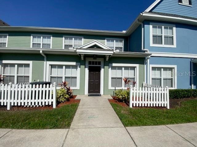 2203 San Vittorino Cir Unit 103, Kissimmee, FL 34741 - view of front facade featuring fence and stucco siding