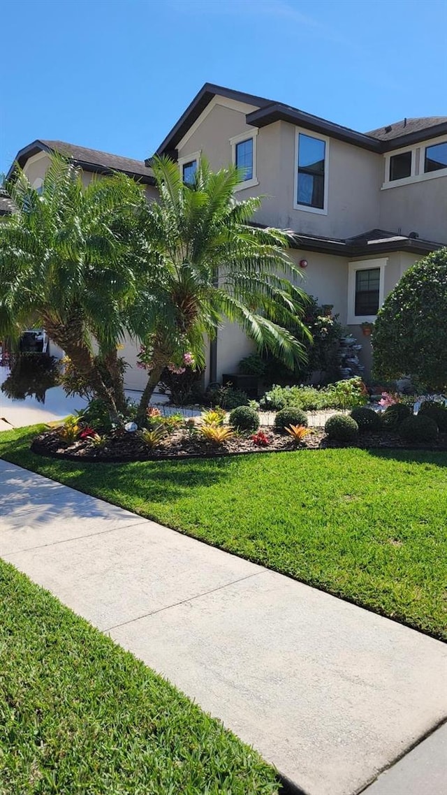 2289 Seven Oaks Dr, Saint Cloud, FL 34772 - view of front of property with stucco siding and a front lawn