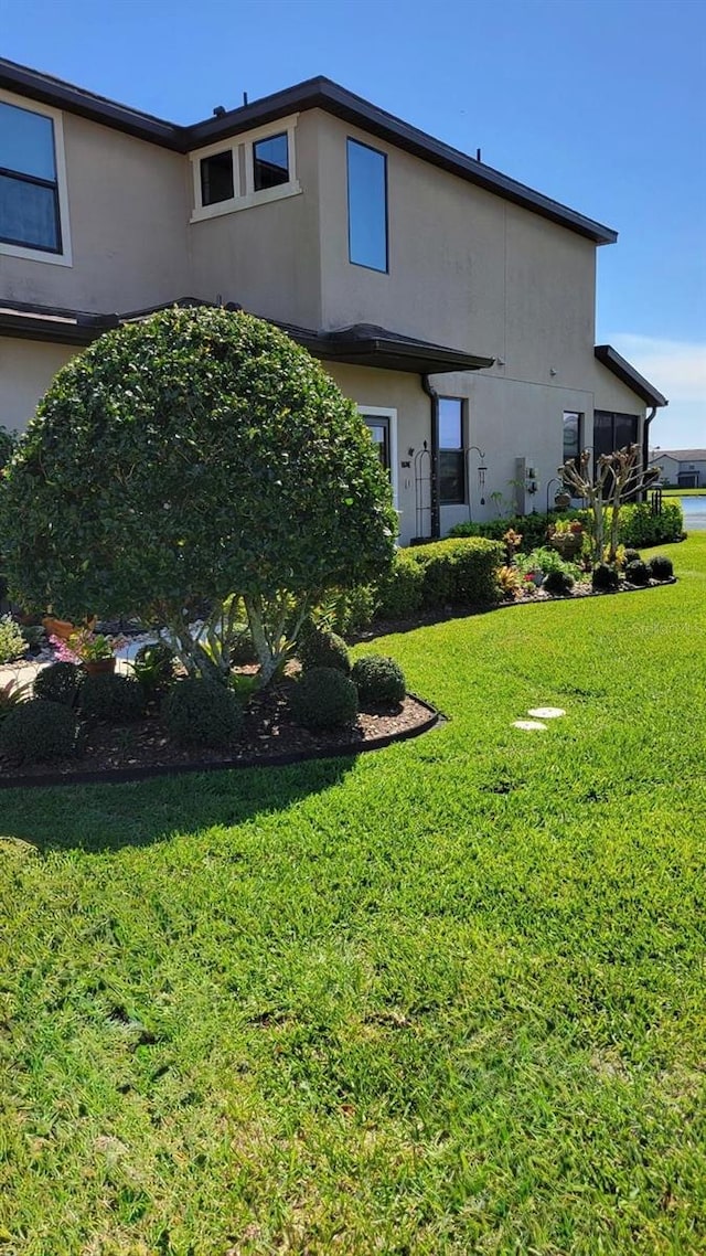 2289 Seven Oaks Dr, Saint Cloud, FL 34772 - rear view of property featuring stucco siding and a lawn