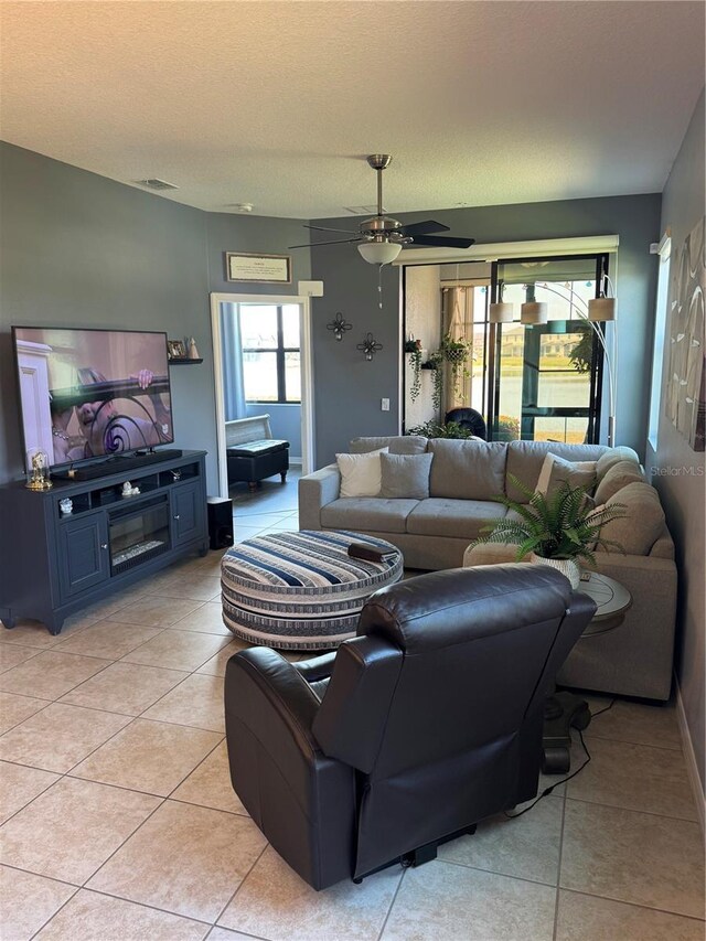 2289 Seven Oaks Dr, Saint Cloud, FL 34772 - living room with light tile patterned floors, ceiling fan, baseboards, and a textured ceiling