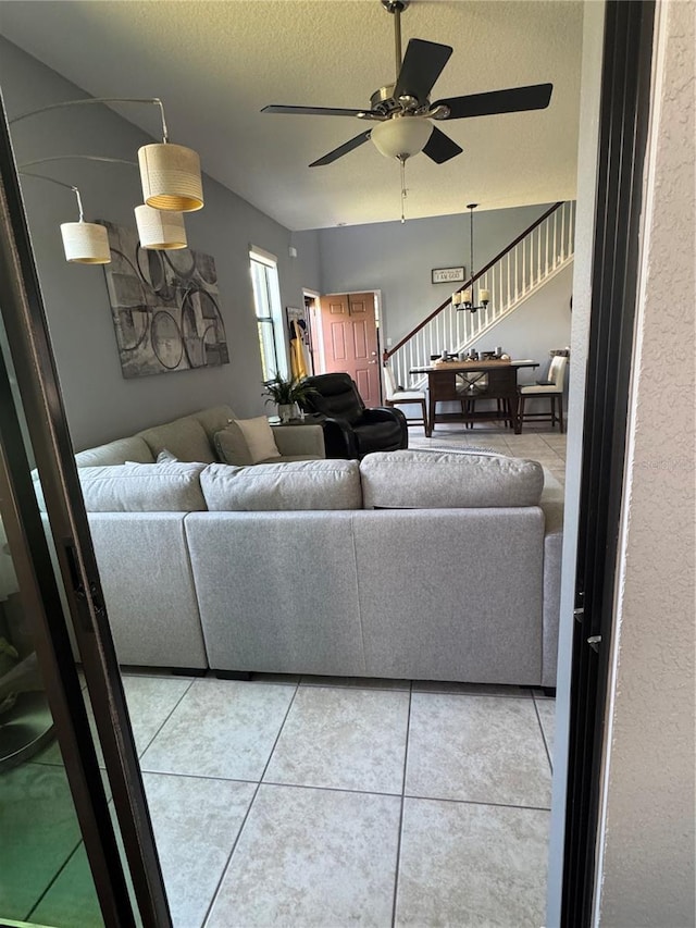 2289 Seven Oaks Dr, Saint Cloud, FL 34772 - living room featuring stairway, ceiling fan, light tile patterned flooring, and a textured ceiling