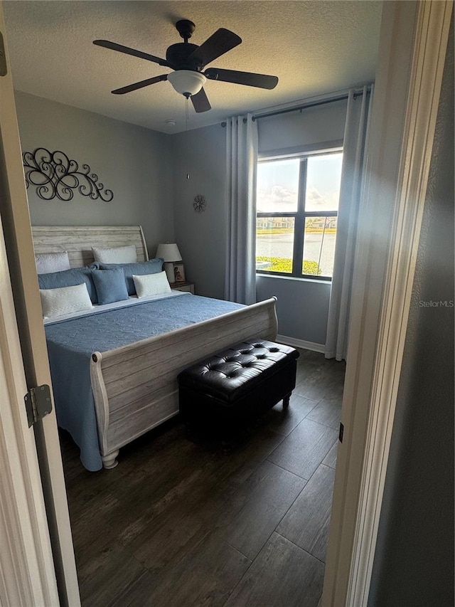 2289 Seven Oaks Dr, Saint Cloud, FL 34772 - bedroom with dark wood-type flooring, a textured ceiling, ceiling fan, and baseboards