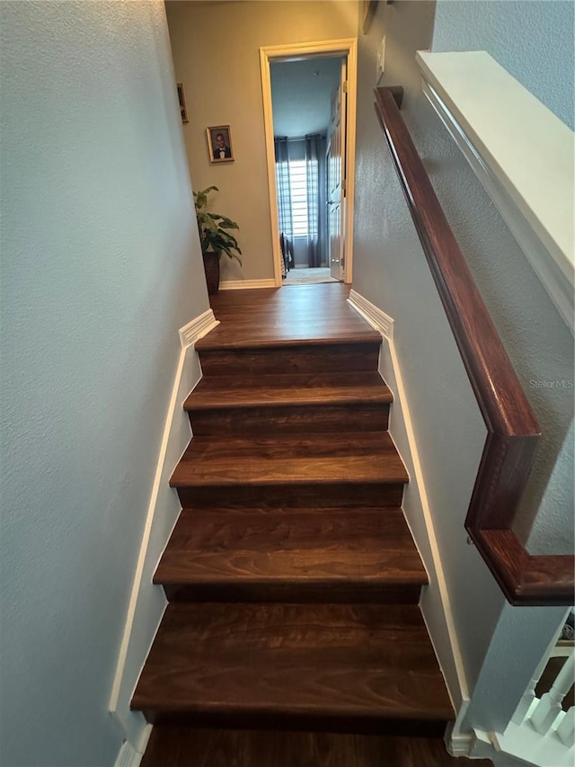 2289 Seven Oaks Dr, Saint Cloud, FL 34772 - staircase with wood finished floors, a textured wall, and baseboards
