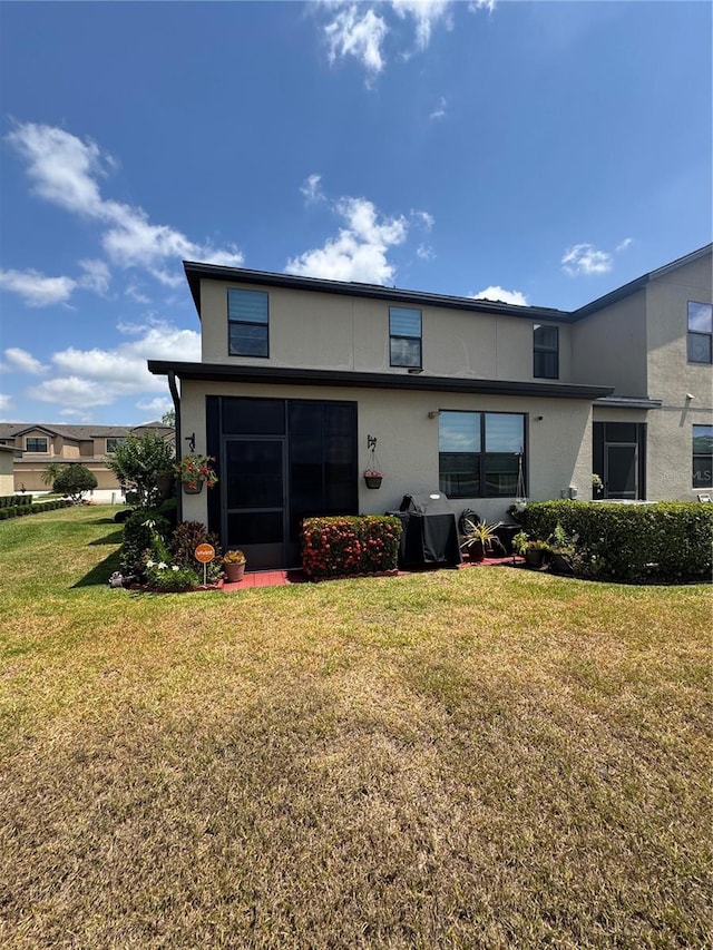 2289 Seven Oaks Dr, Saint Cloud, FL 34772 - rear view of property featuring stucco siding and a yard
