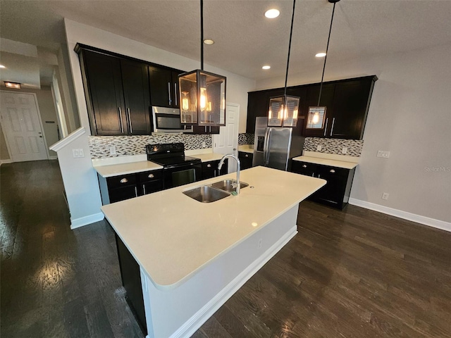 kitchen with stainless steel appliances, a sink, dark wood-type flooring, backsplash, and recessed lighting