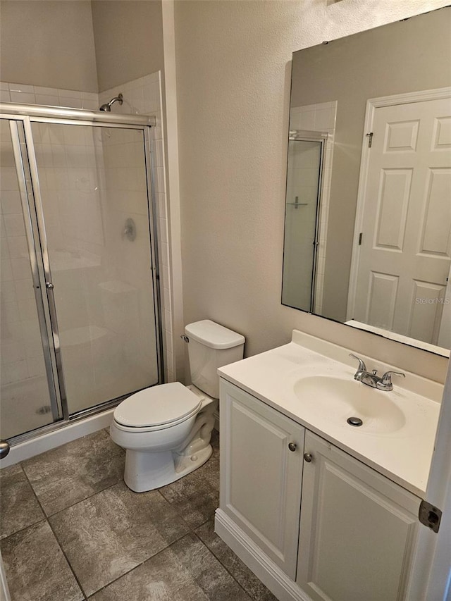full bathroom with a stall shower, toilet, and vanity