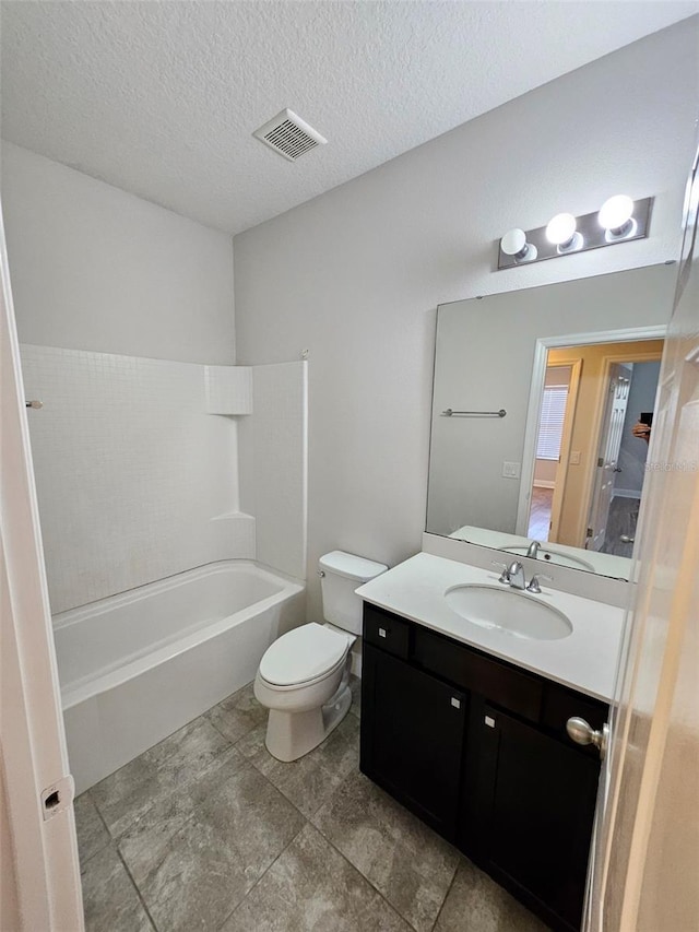 full bathroom featuring toilet, vanity, tile patterned flooring, bathing tub / shower combination, and a textured ceiling
