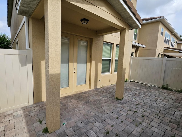 view of patio featuring french doors and fence