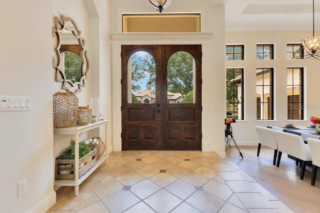 entryway featuring plenty of natural light, a chandelier, and baseboards