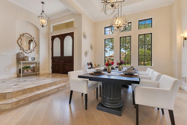 dining room with a chandelier, baseboards, wood finished floors, and ornamental molding