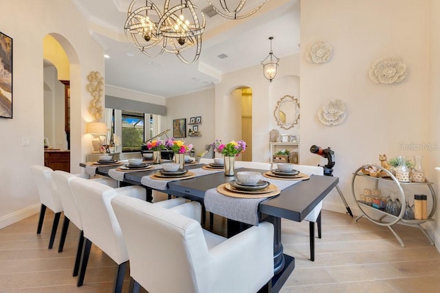 dining space with arched walkways, crown molding, baseboards, and light wood-style floors