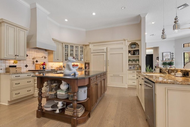 kitchen featuring open shelves, cream cabinets, a center island with sink, dishwasher, and ornamental molding