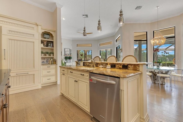 kitchen with dishwasher, cream cabinets, a sink, light wood-style floors, and crown molding