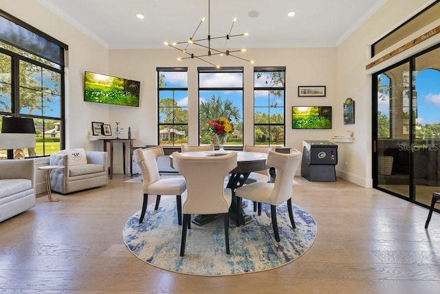 dining room with a chandelier, crown molding, baseboards, light wood-style flooring, and recessed lighting