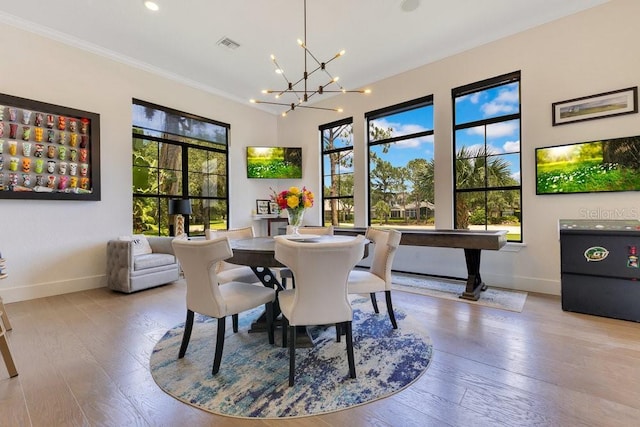 dining area with baseboards, a chandelier, wood-type flooring, crown molding, and recessed lighting