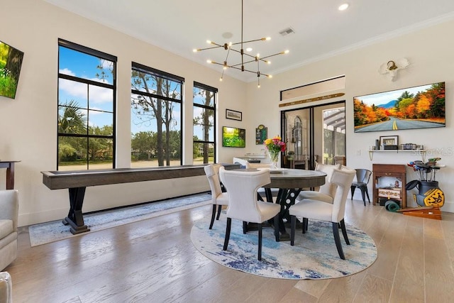 dining room with a chandelier, ornamental molding, wood finished floors, baseboards, and recessed lighting