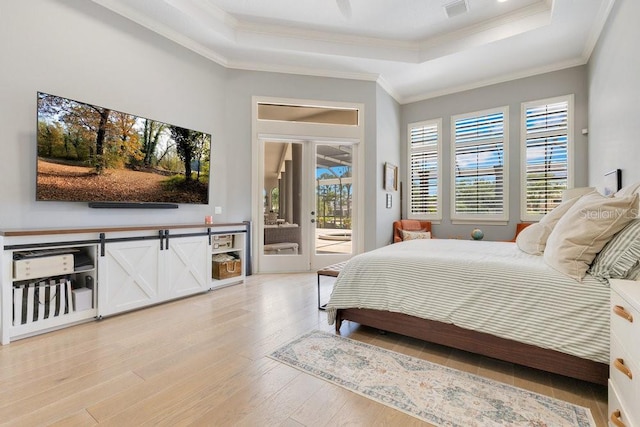 bedroom featuring a raised ceiling, access to outside, light wood-style flooring, and crown molding