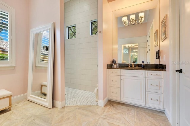 full bathroom with a chandelier, walk in shower, healthy amount of natural light, and vanity