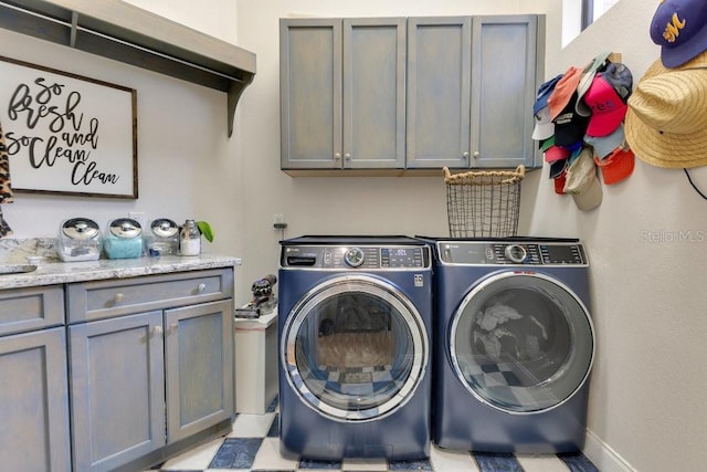 laundry room featuring cabinet space, washing machine and dryer, and baseboards