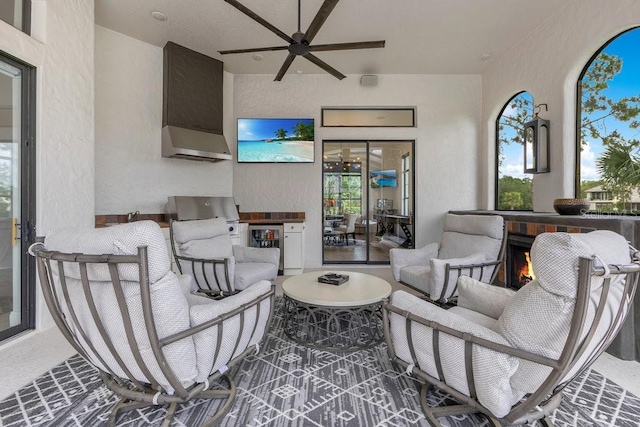 view of patio / terrace featuring an outdoor living space, a ceiling fan, beverage cooler, an outdoor kitchen, and a grill
