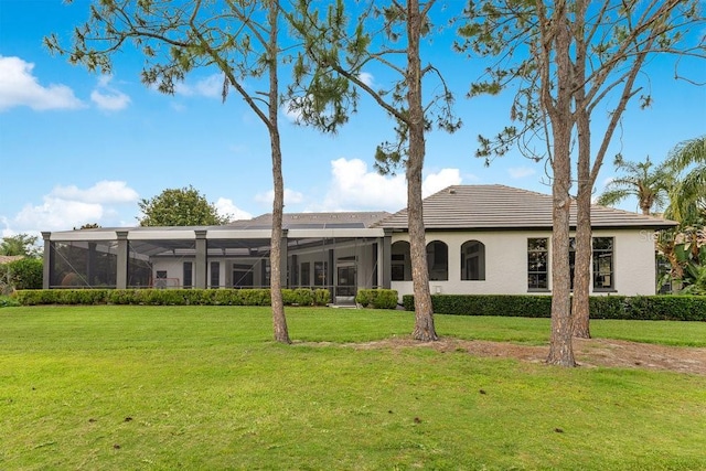 back of property featuring a lawn, a lanai, and stucco siding