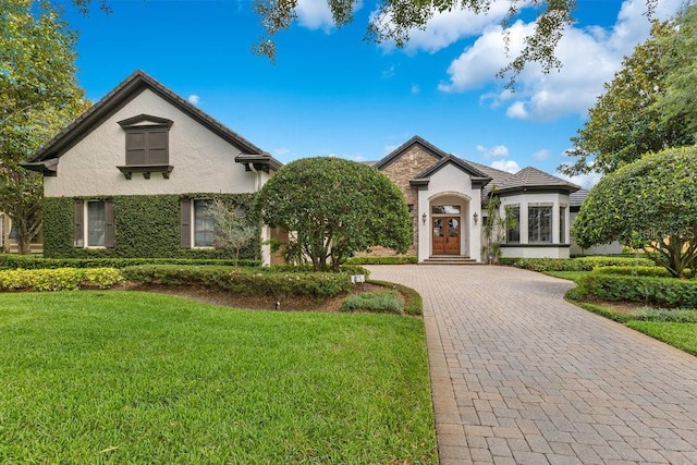 6761 Valhalla Way, Windermere, FL 34786 - view of front of home featuring decorative driveway, a front yard, stucco siding, and french doors