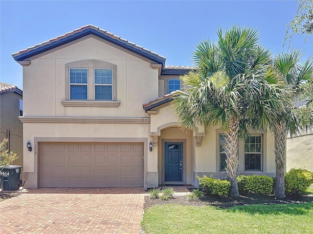 1614 Lima Ave, Kissimmee, FL 34747 - mediterranean / spanish house with decorative driveway, stucco siding, an attached garage, and a tiled roof