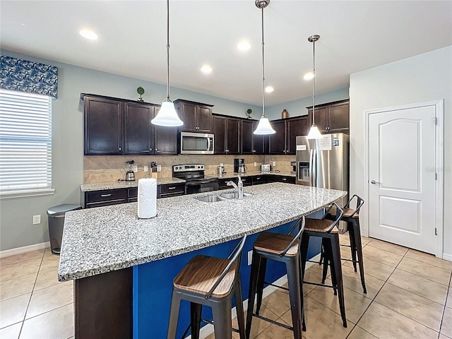 1614 Lima Ave, Kissimmee, FL 34747 - kitchen with stainless steel appliances, a sink, a kitchen bar, dark brown cabinetry, and recessed lighting