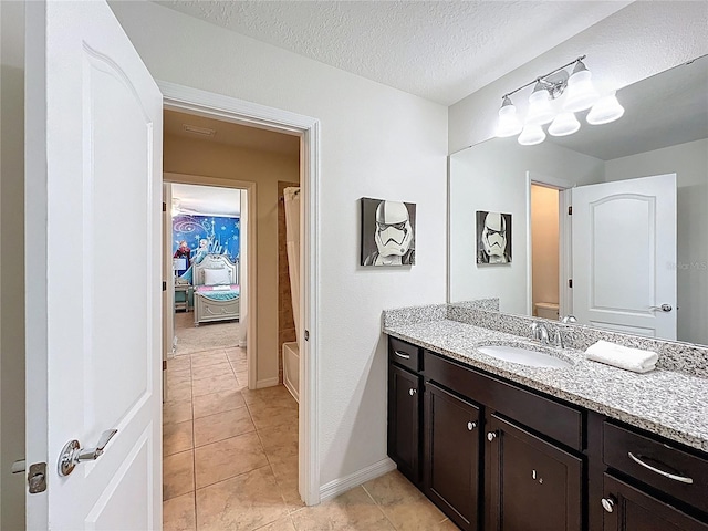 1614 Lima Ave, Kissimmee, FL 34747 - full bath with vanity, tile patterned floors, baseboards, and a textured ceiling