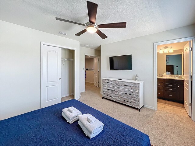 1614 Lima Ave, Kissimmee, FL 34747 - bedroom with light carpet, ceiling fan, a textured ceiling, ensuite bath, and a closet