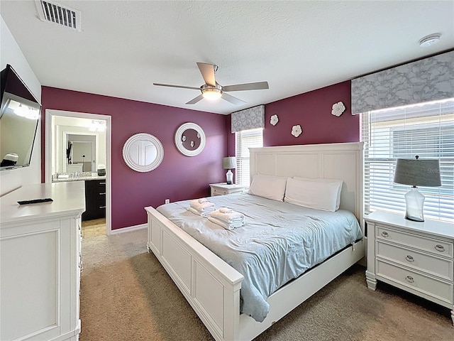 1614 Lima Ave, Kissimmee, FL 34747 - bedroom with light colored carpet, multiple windows, ceiling fan, and ensuite bath