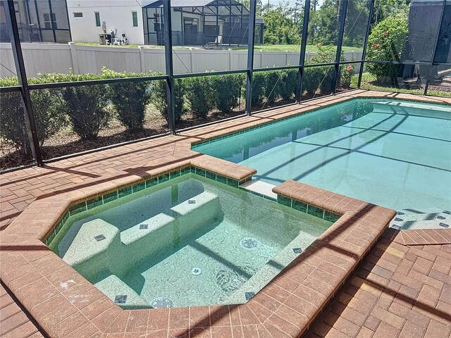 1614 Lima Ave, Kissimmee, FL 34747 - view of swimming pool with a pool with connected hot tub, glass enclosure, and a patio area