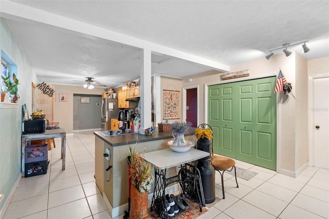303 Thrush Ave, Sebring, FL 33870 - kitchen featuring light tile patterned flooring, freestanding refrigerator, dark countertops, baseboards, and a textured ceiling