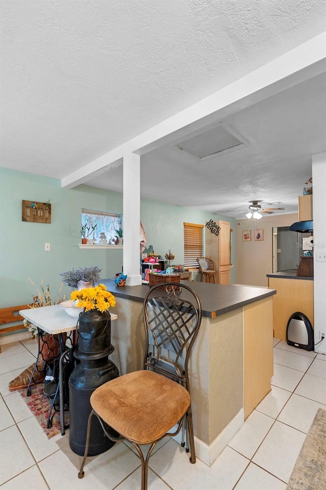 303 Thrush Ave, Sebring, FL 33870 - kitchen with light tile patterned flooring, a peninsula, dark countertops, and a textured ceiling